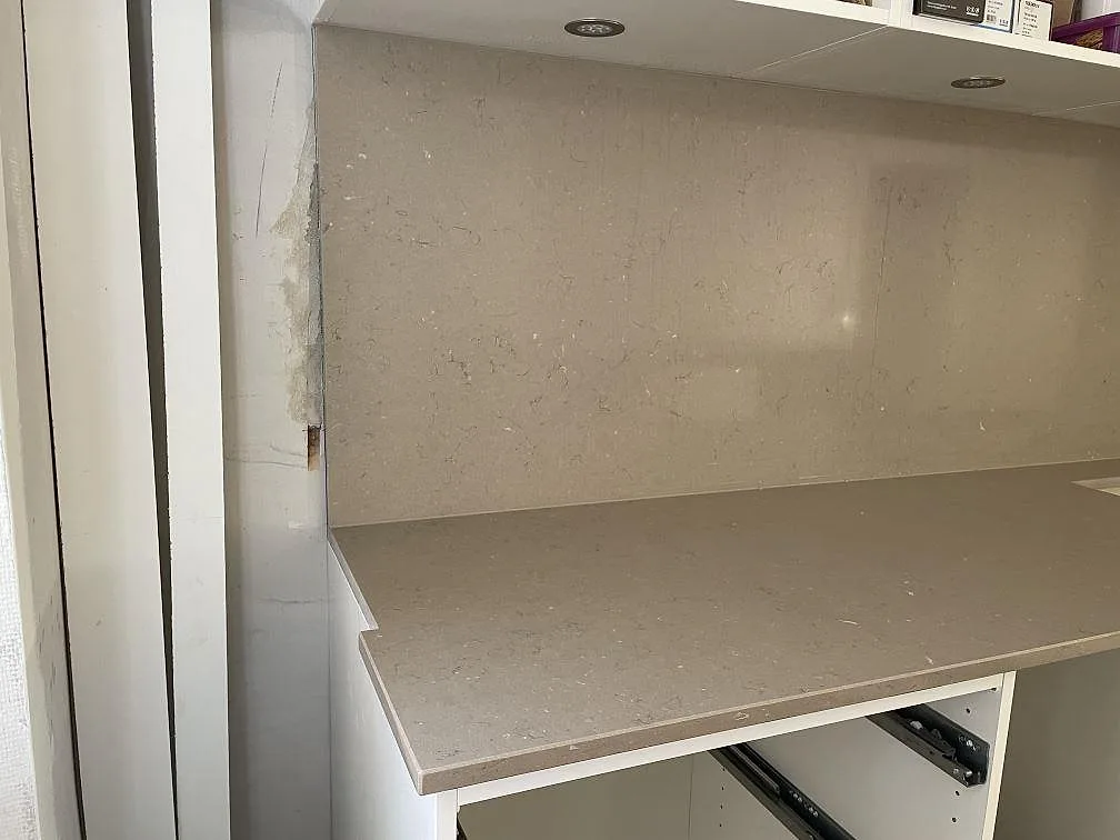 Bänkskiva och stänkskydd i Silestone Coral Clay komposit, polerad, monterade vid vita stommar i Helsingborg.