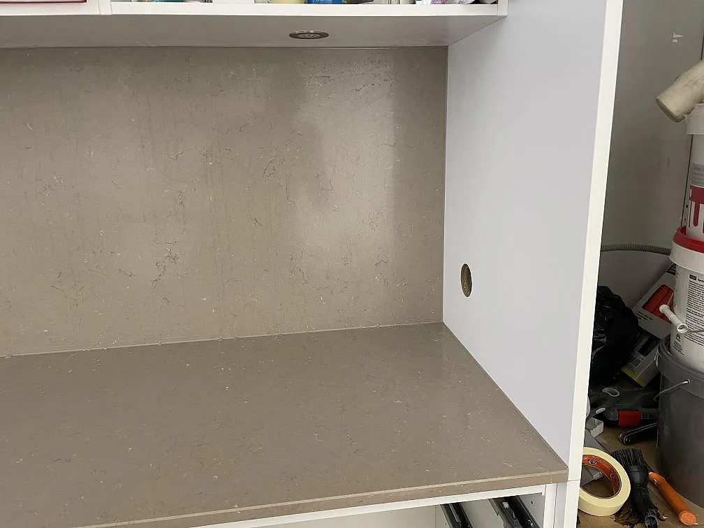Detalj av Silestone Coral Clay komposit som bänkskiva och uppvikt stänkkant under överskåp i Helsingborg.