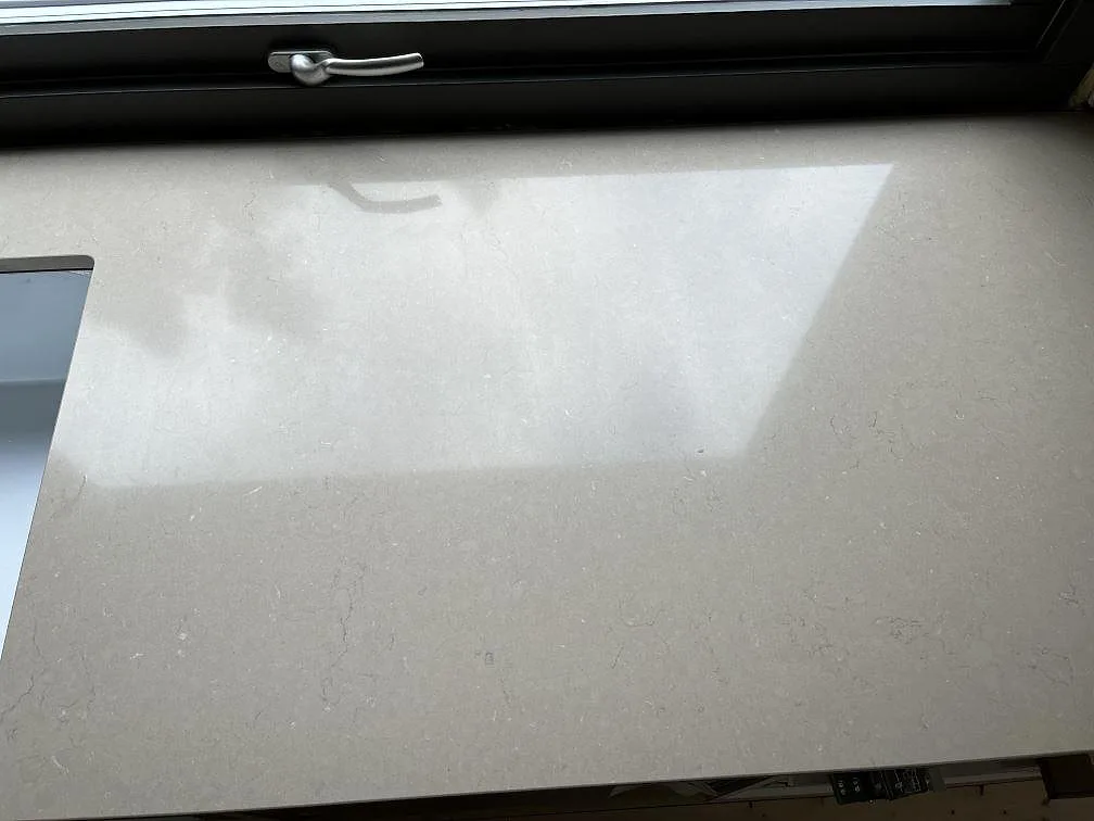 Polerad bänkskiva i Silestone Coral Clay med spegelblank yta vid ett fönster i ett kök i Hestra.