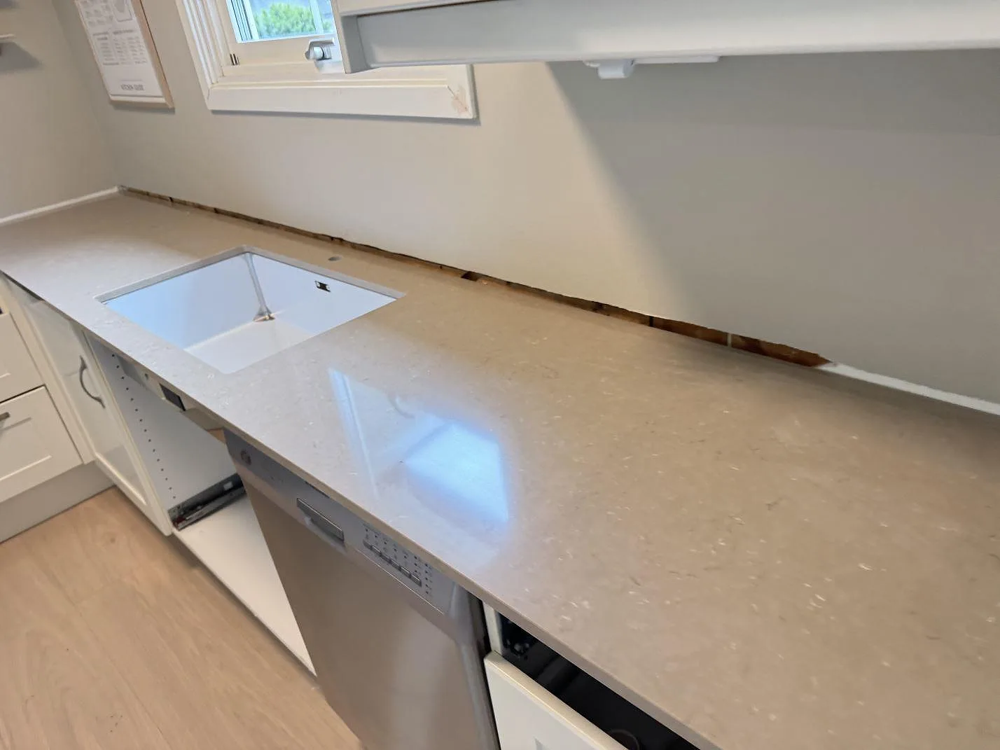 Närbild av köksbänkskiva i Silestone Coral Clay, polerad komposit, med diskhoöppning under montering i Hisings Backa.