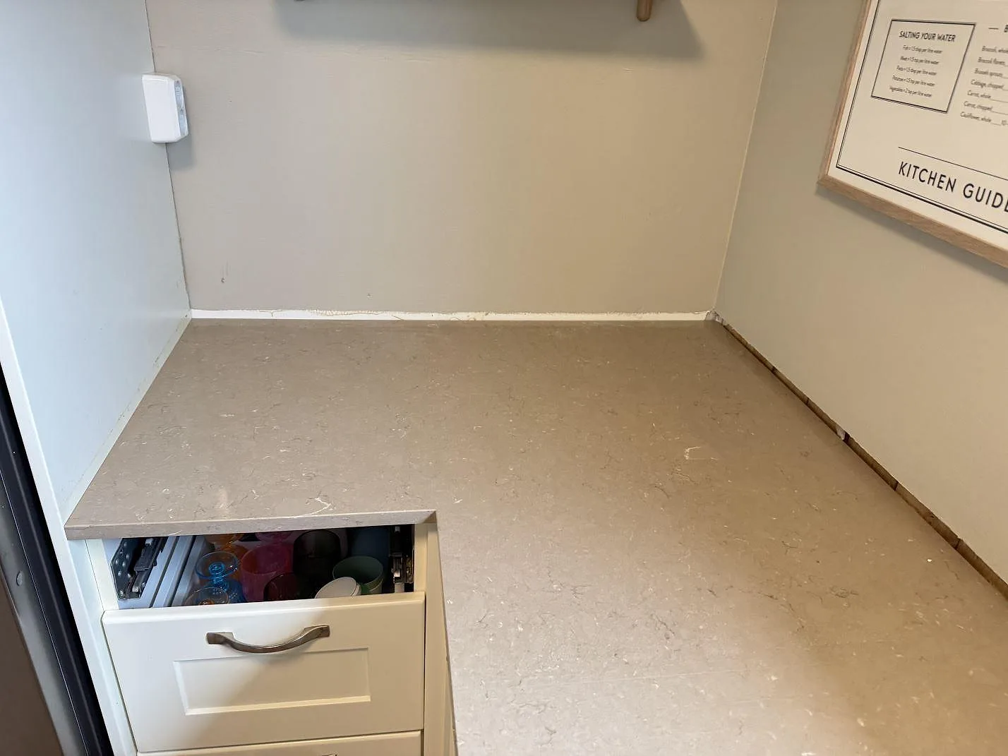 Arbetsyta i polerad Silestone Coral Clay, varm beigegrå komposit, monterad mot vägg i ett kök i Hisings Backa.