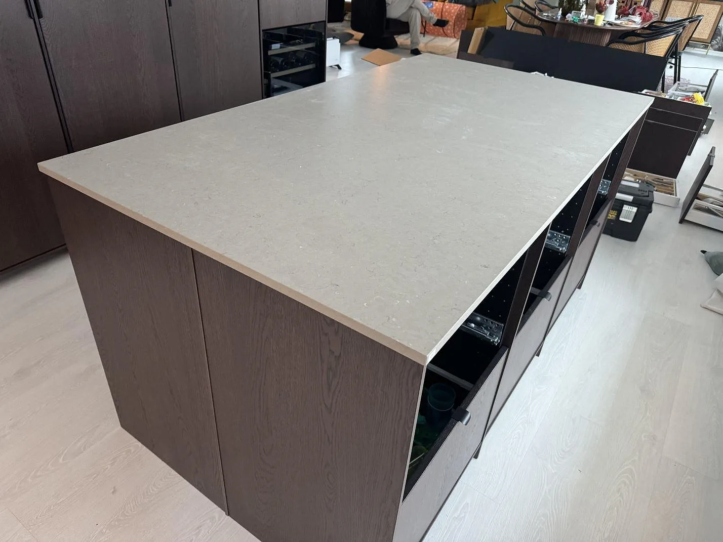 Stor köksö i Silestone Coral Clay, matt greige kvartskomposit, monterad i ett kök med mörk träinredning i Höganäs.