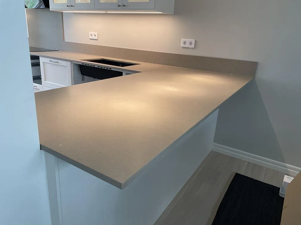 L-formad bänkskiva och halvö i gråbeige Silestone Coral Clay med matt Mocka-yta i Höllviken.