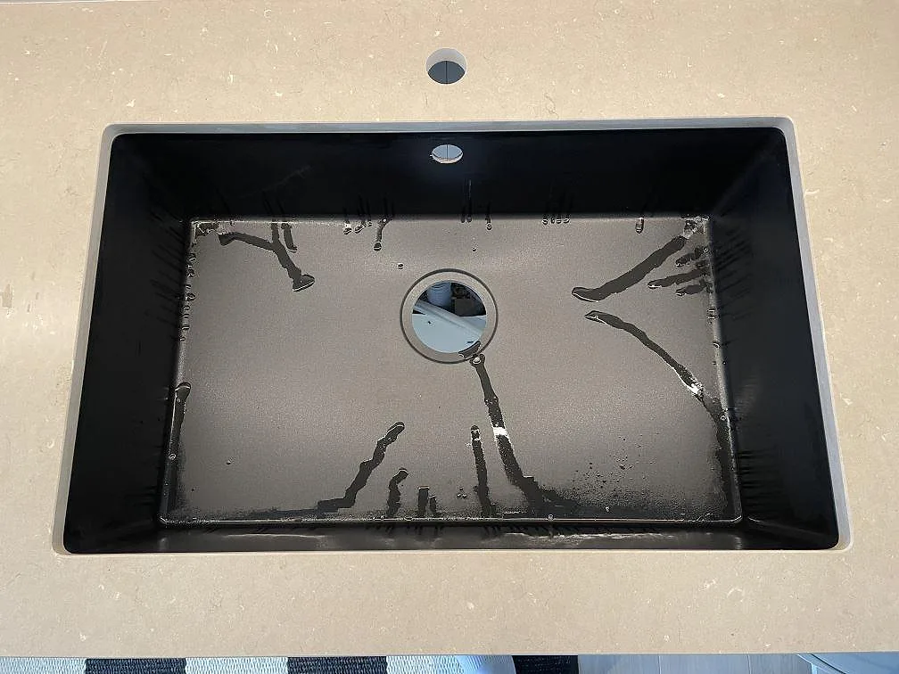 Svart underlimmad diskho med blandarhål i en matt Silestone Coral Clay bänkskiva i Höllviken.