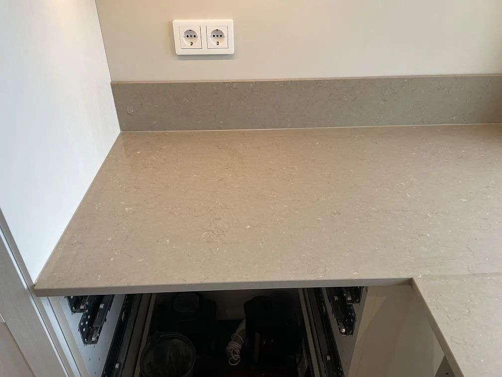 Närbild på Silestone Coral Clay bänkskiva och lågt stänkskydd med matt Mocka-finish i Höllviken.