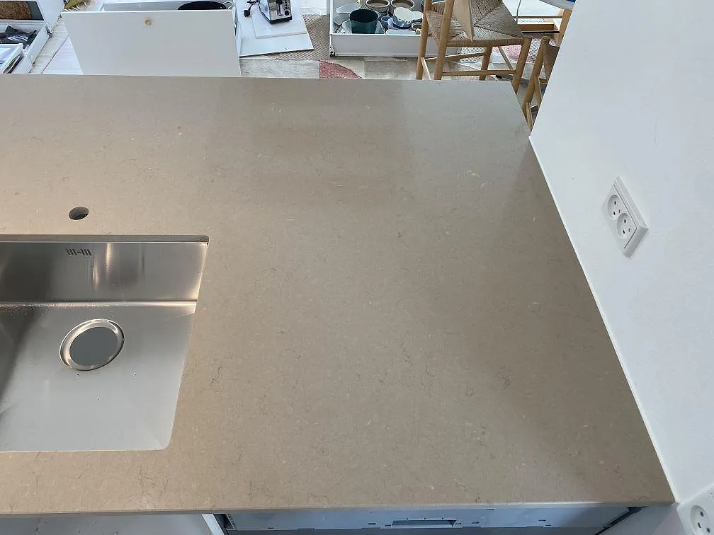 Underlimmad rostfri diskho med separat borrat blandarhål i en köksö av Silestone Coral Clay, polerad komposit, i ett kök i Hørsholm.