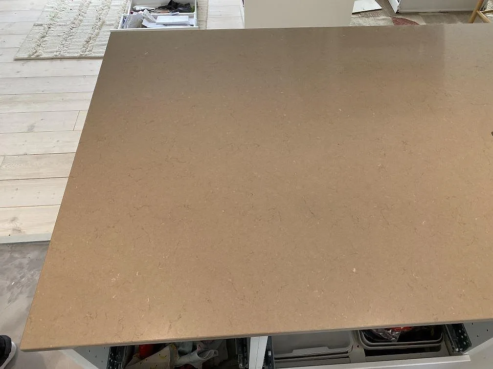 Köksö i Silestone Coral Clay, polerad kvartskomposit, där den varma gräbeige tonen och den finkorniga ytan syns ovanifrån i ett kök i Hørsholm.