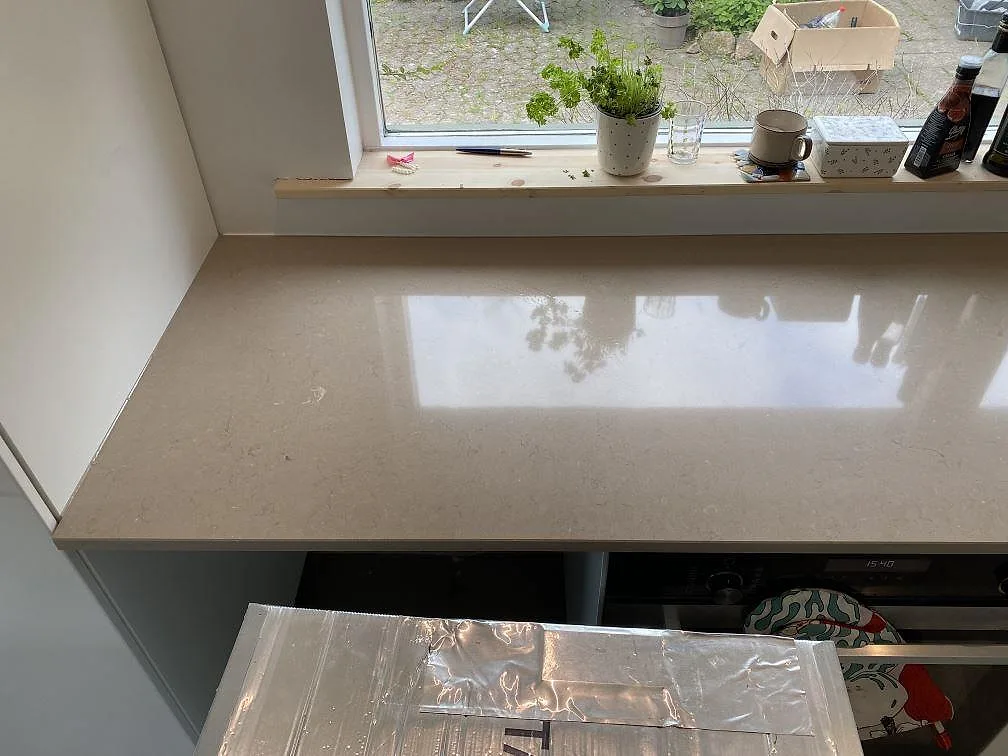 Polerad köksbänkskiva i Silestone Coral Clay i ett fönsterhörn under montering i ett kök i Hørsholm.