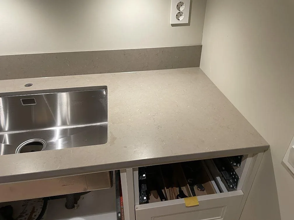Detalj av Silestone Coral Clay bänkskiva i Mocka med rostfri diskho och låg stänkkant i ett kök i Vetlanda.