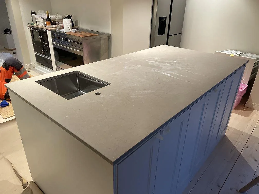 Köksö med bänkskiva i Silestone Coral Clay, Mocka, och underlimmad rostfri diskho i ett kök i Vetlanda.