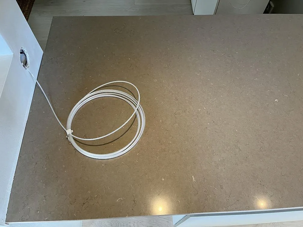 Ovanifrån av polerad Silestone Coral Clay köksbänkskiva med varm taupe ton och mjuk ådring i ett kök i Ingelstad.
