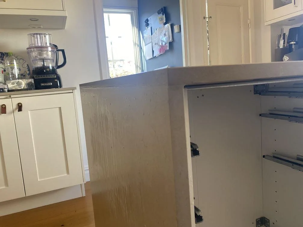 Detalj av hörn, kantprofil och sidoskiva i matt Silestone Coral Clay komposit på köksö i Jönköping.