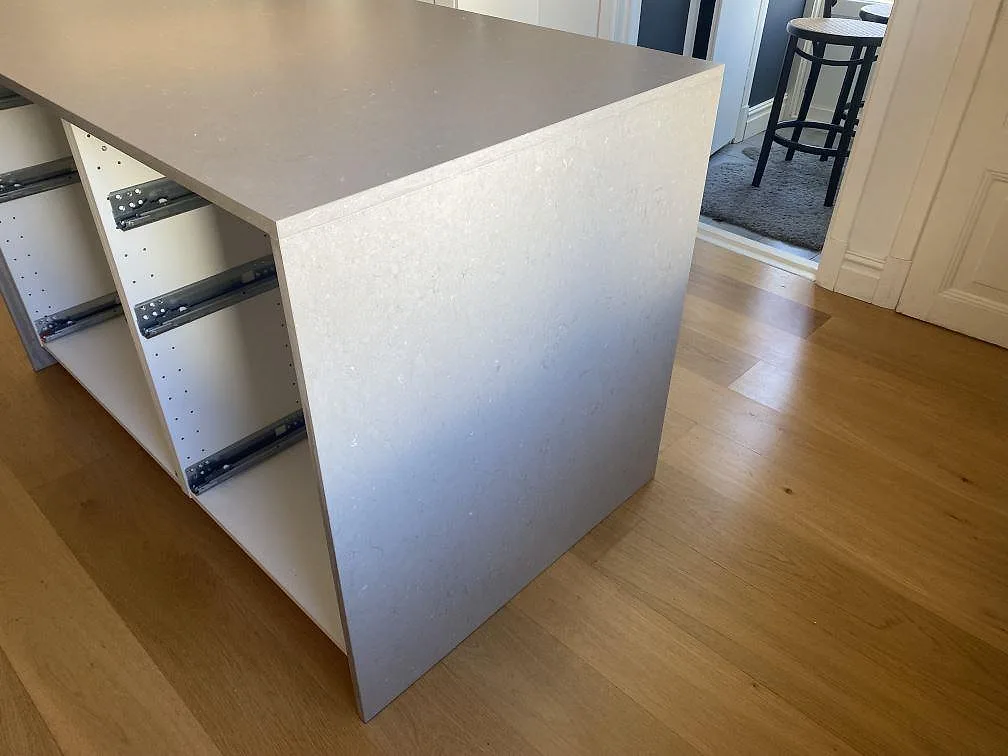 Närbild av köksö med bänkskiva och neddragen sida i matt Silestone Coral Clay komposit i Jönköping.