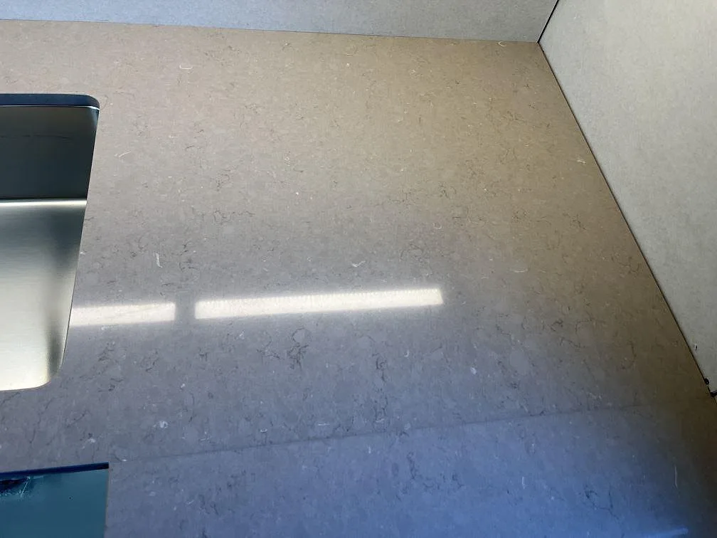 Hörn av köksbänkskiva i Silestone Coral Clay vid den underlimmade rostfria diskhon, ovanvy i ett kök i Kållered.
