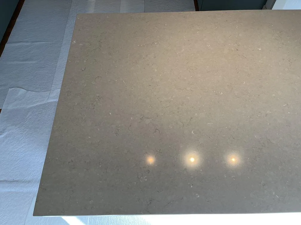 Köksö i Silestone Coral Clay, matt kaffebeige kvartskomposit med diskret ådring, ovanvy i ett kök under montering i Kållered.
