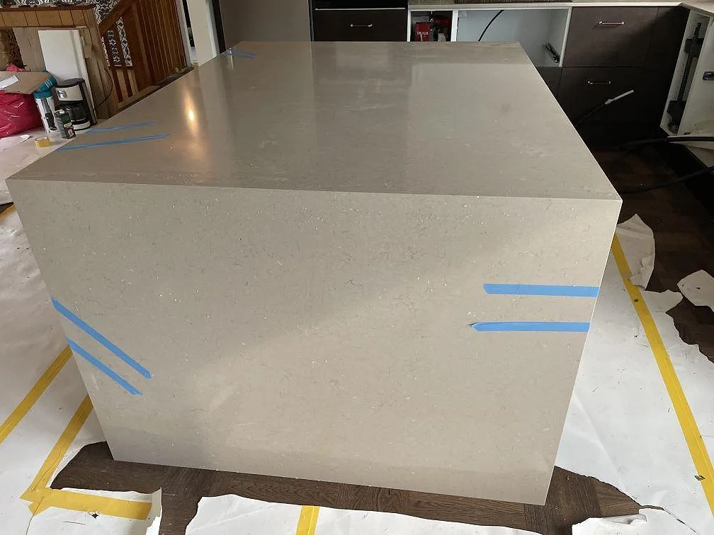 Framsida av köksö i Silestone Coral Clay komposit med polerad yta och synliga monteringstejper i Kållered.