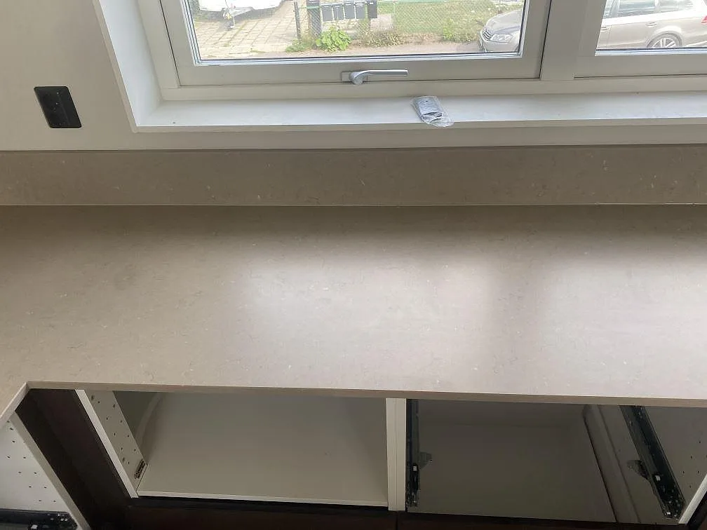 Bänkskiva och fönsterbänk i matt Silestone Coral Clay komposit över öppna köksstommar i ett kök i Kalmar.
