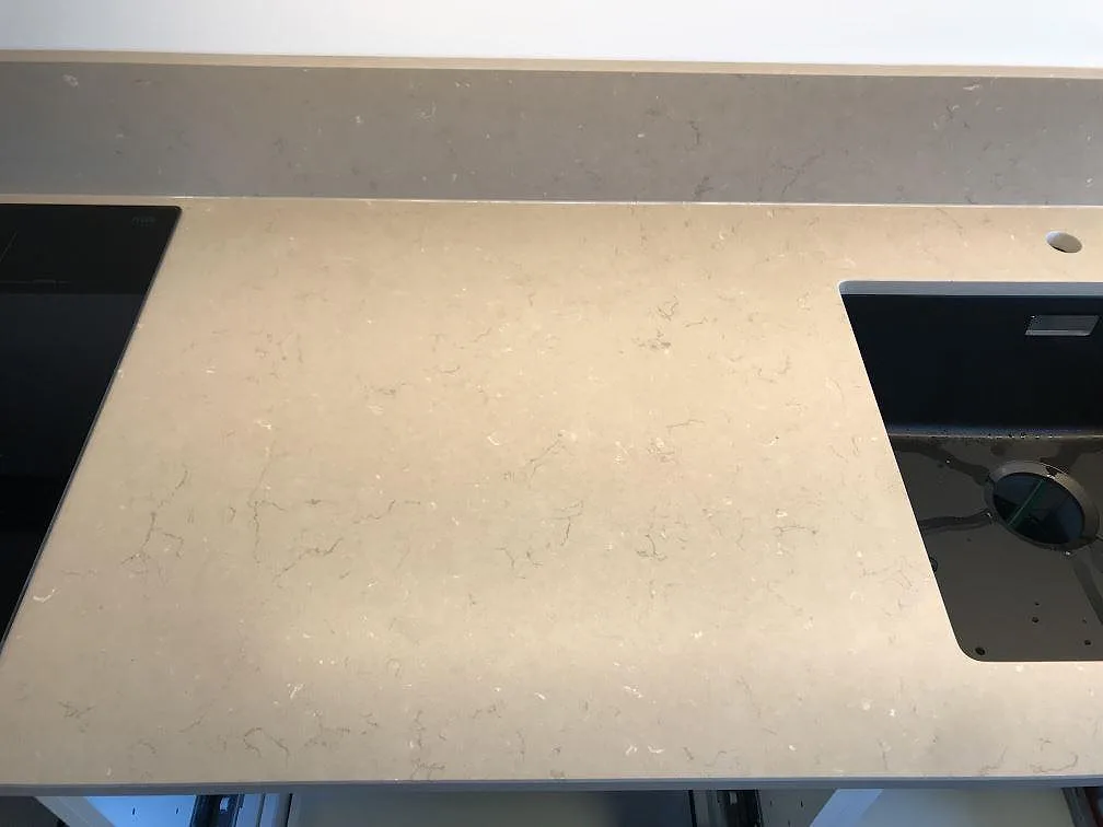 Bänkskiva i Silestone Coral Clay sedd ovanifrån med urtag för häll och underlimmad diskho med blandarhål, matt finish, i ett kök i Kalmar.