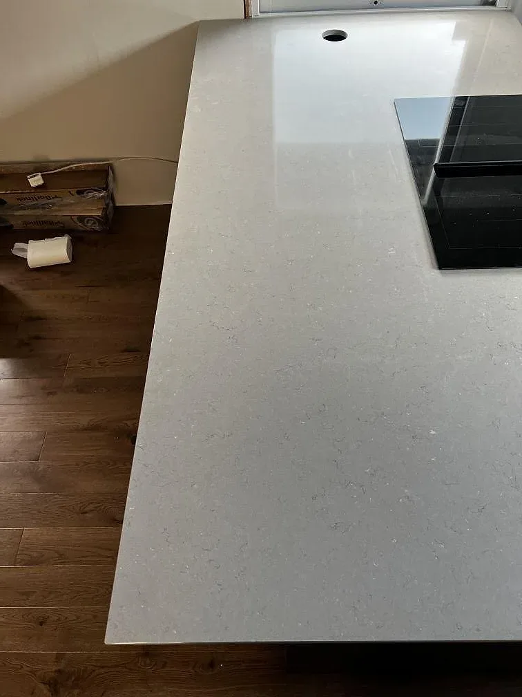 Ytnära bild av polerad Silestone Coral Clay med häll och ljus kompositstruktur i köksö i Kalmar.