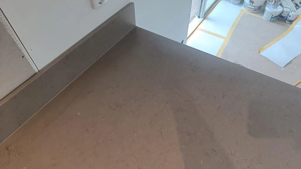 Detalj av matt Silestone Coral Clay med uppvikt stänkkant och varm gråbeige struktur i Kalmar.