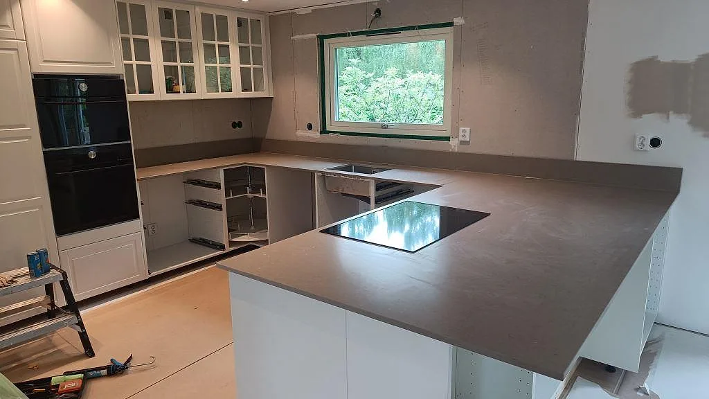 Köksbänkskiva i Silestone Coral Clay, matt Mocka, med halvö och infälld häll i ett kök i Kalmar.