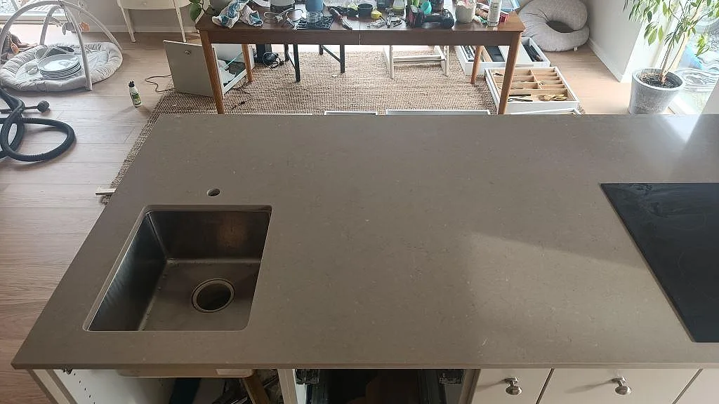 Polerad bänkskiva i Silestone Coral Clay sett uppifrån med underlimmad rostfri diskho och kranhål i ett kök i Kareby.
