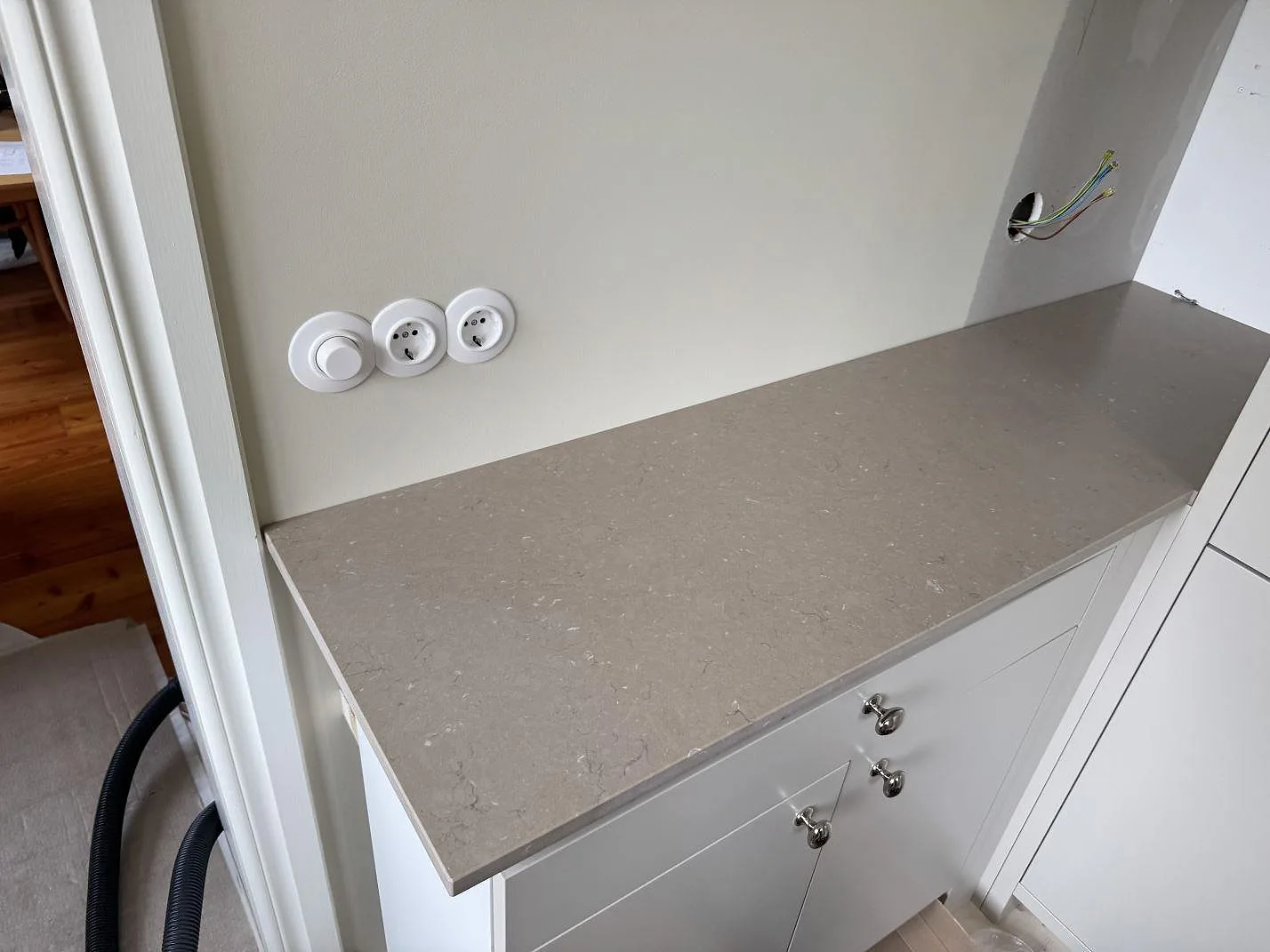 Kort bänkskiva i Silestone Coral Clay, matt Mocka, monterad över vita underskåp i Karlskrona.
