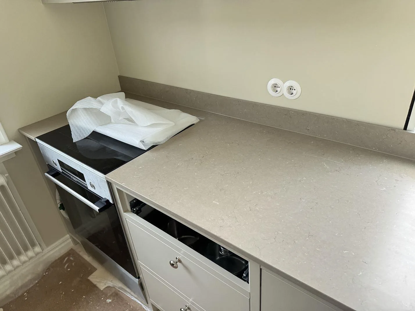 Köksbänkskiva i matt Silestone Coral Clay med lång arbetsyta och stänkkant runt spisen i Karlskrona.