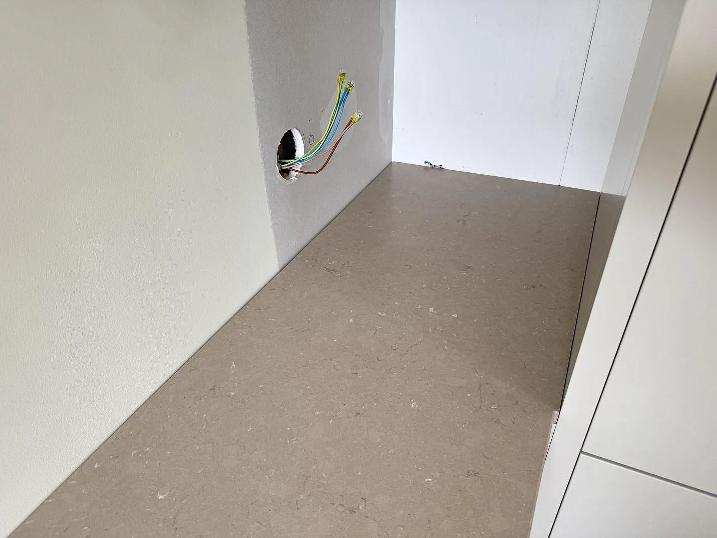 Installerad bänkskiva i Silestone Coral Clay, matt Mocka, i en nisch med vägganslutning i Karlskrona.