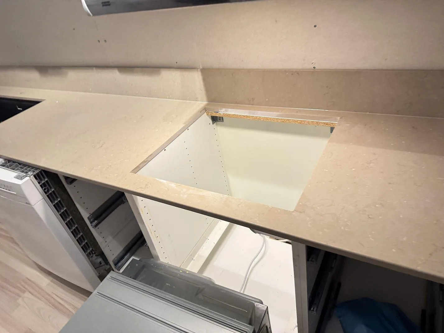 Detalj av öppet urtag i polerad Silestone Coral Clay med 12 mm stänkkant och öppna köksstommar i Karlskrona.
