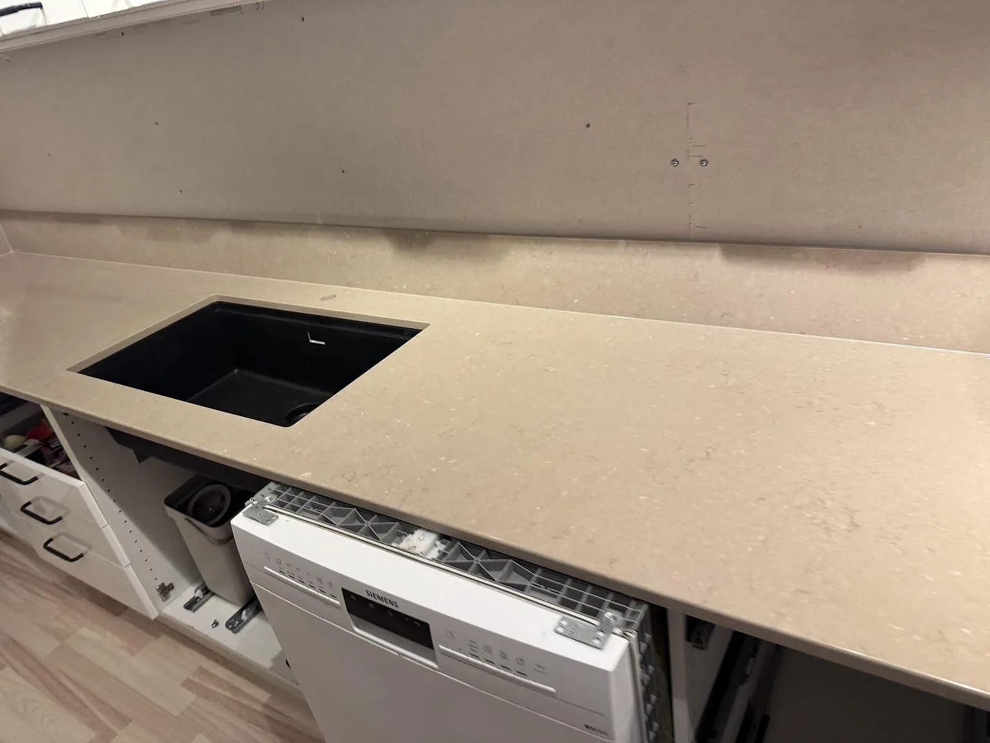 Närbild av köksbänkskiva i polerad Silestone Coral Clay med svart diskho och 12 mm stänkkant i Karlskrona.