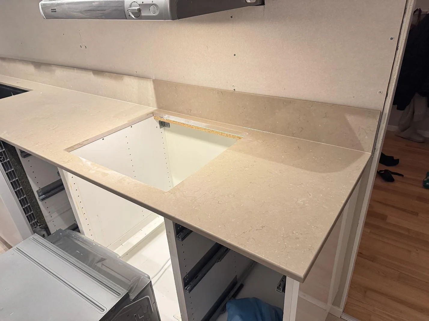 Polerad köksbänkskiva i Silestone Coral Clay med öppet urtag under fläkten och matchande stänkkant i Karlskrona.