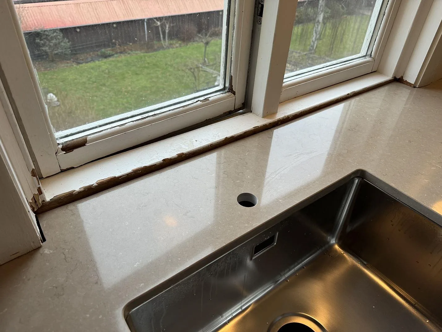 Köksbänkskiva i polerad Silestone Coral Clay med rostfri diskho och fönsternisch i Kastrup.