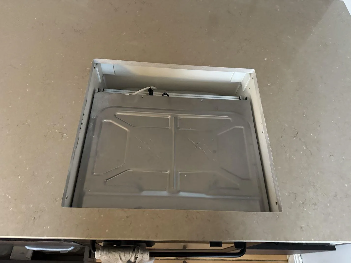 Detalj av hällöppning i köksö med polerad Silestone Coral Clay komposit i Kastrup.