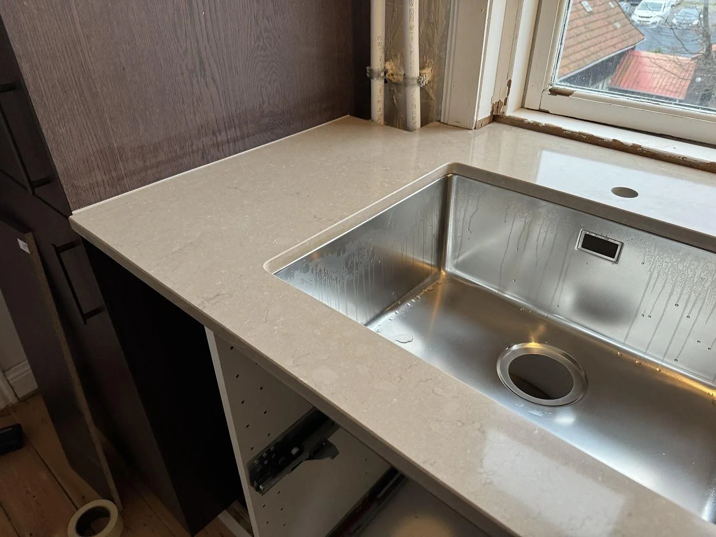 Polerad köksbänkskiva i Silestone Coral Clay med underlimmad rostfri diskho och fönsterljus i Kastrup.