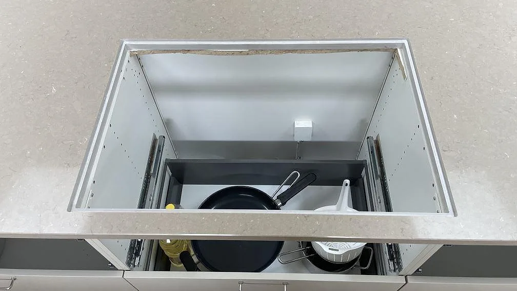 Urtag för häll i köksön av polerad Silestone Coral Clay, 30 mm kvartskomposit, med öppna köksstommar i København.