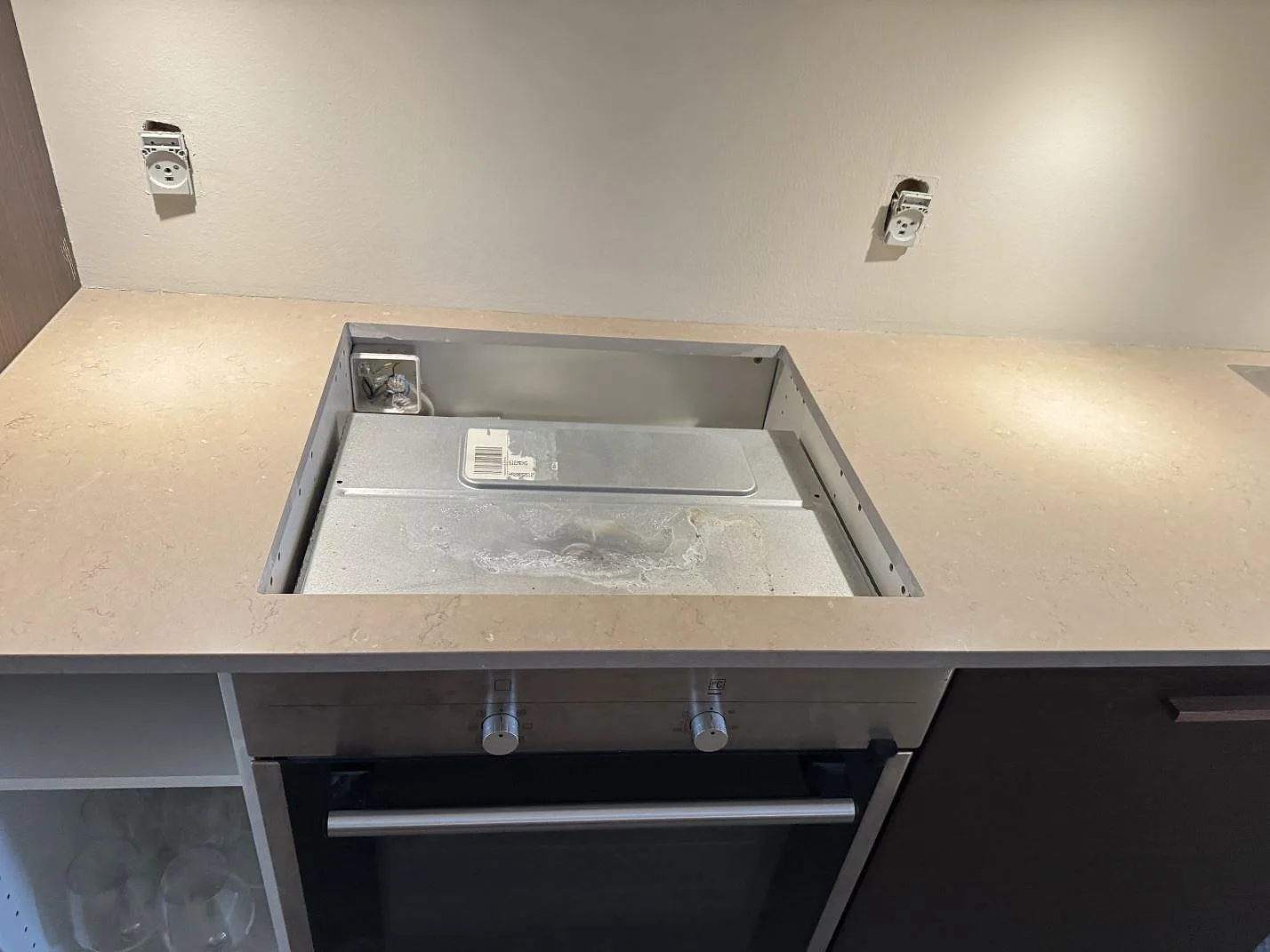 Bänkskiva i polerad Silestone Coral Clay med hällöppning över ugn i kök i København.