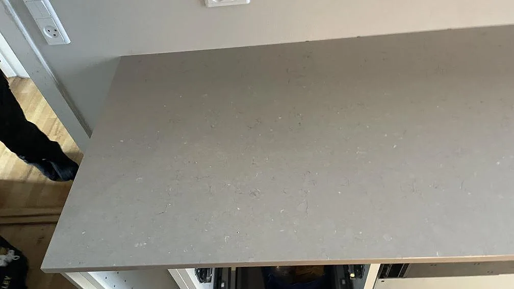 Närbild på den polerade ytan i Silestone Coral Clay, gråbeige komposit monterad som köksbänkskiva i København N.