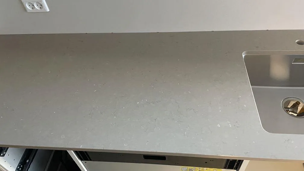Polerad Silestone Coral Clay som köksbänkskiva med rostfri diskho vid vägg, komposit i ett kök i København N.