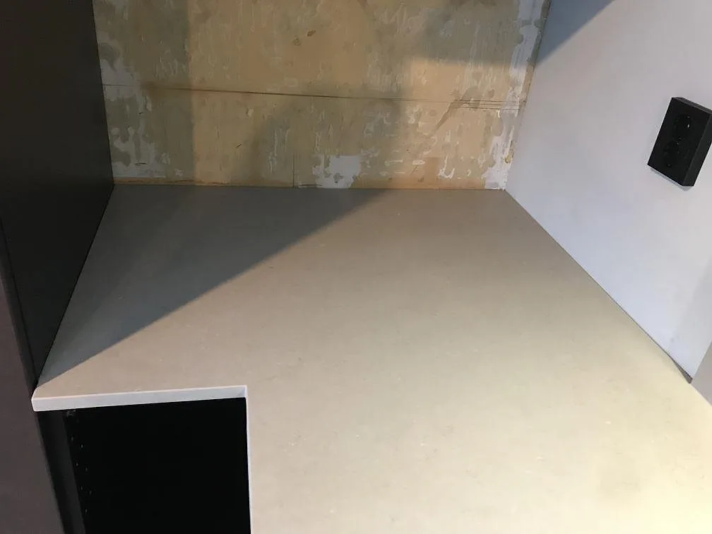 Matt Silestone Coral Clay bänkskiva monterad mot vägg och mörka stommar i ett kök under montering i Kungsbacka.
