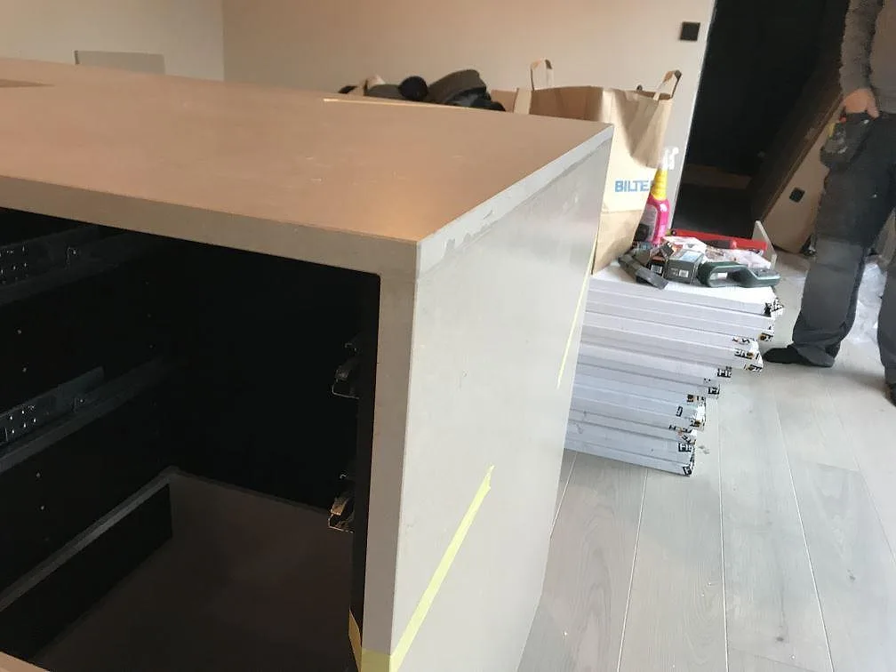 Närbild av köksö i matt Silestone Coral Clay, gråbeige kvartskomposit, med monterad sten som huvudmotiv i Kungsbacka.
