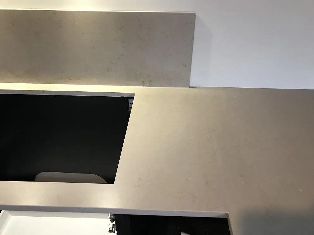 Bänkskiva i Silestone Coral Clay med uppställt stänkskydd i samma sten längs väggen i ett kök i Kungsbacka.