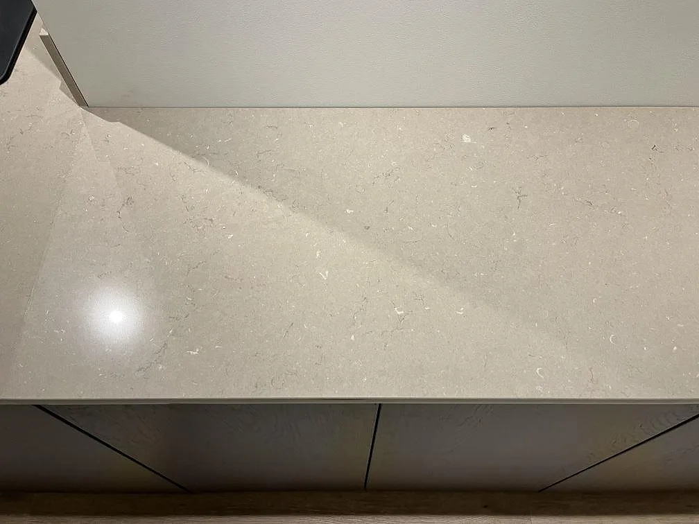 Köksbänkskiva i Silestone Coral Clay i taupe-beige kvartskomposit ovanpå köksstommar i ett kök i Kungshamn.