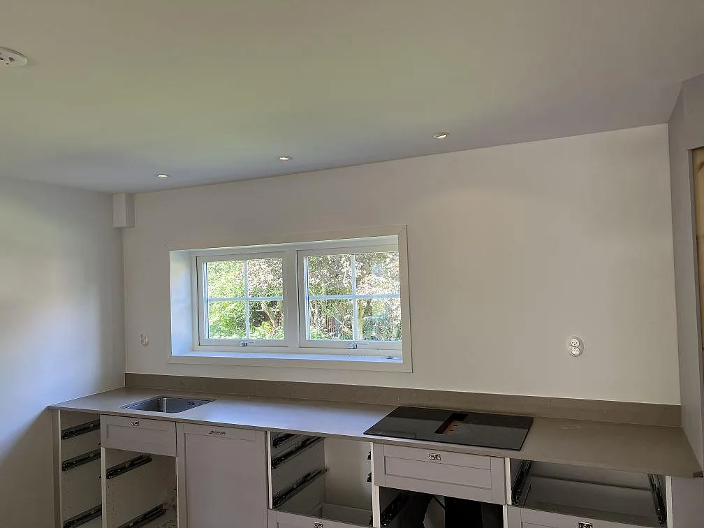 Köksbänkskiva i Silestone Coral Clay komposit, Mocka, med underlimmad rostfri diskho och svart induktionshäll i Långås.