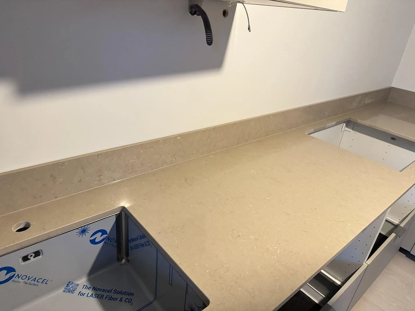 Väggbänk i polerad Silestone Coral Clay, 20 mm komposit, med diskho och hällöppning samt låg stänkkant i Länghem.