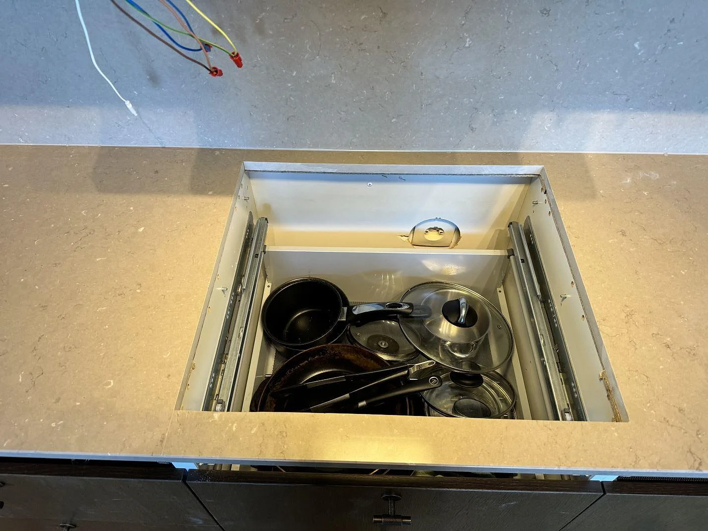 Närbild på hällöppning i köksbänkskiva av polerad Silestone Coral Clay under montering i Landskrona.