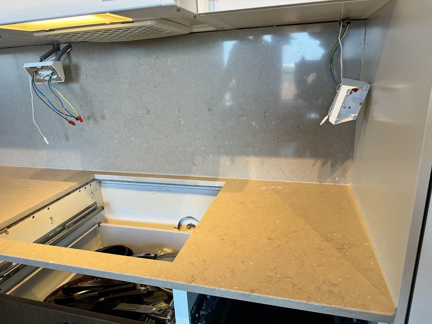Hällöppning i polerad Silestone Coral Clay med matchande grått stänkskydd under montering i Landskrona.