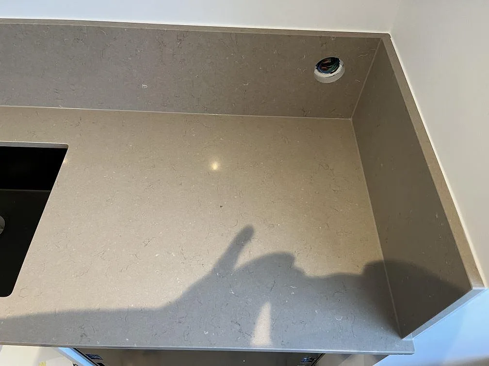 Köksbänkskiva i Silestone Coral Clay med underlimmad svart diskho och uttag i stänkkanten, Limhamn.