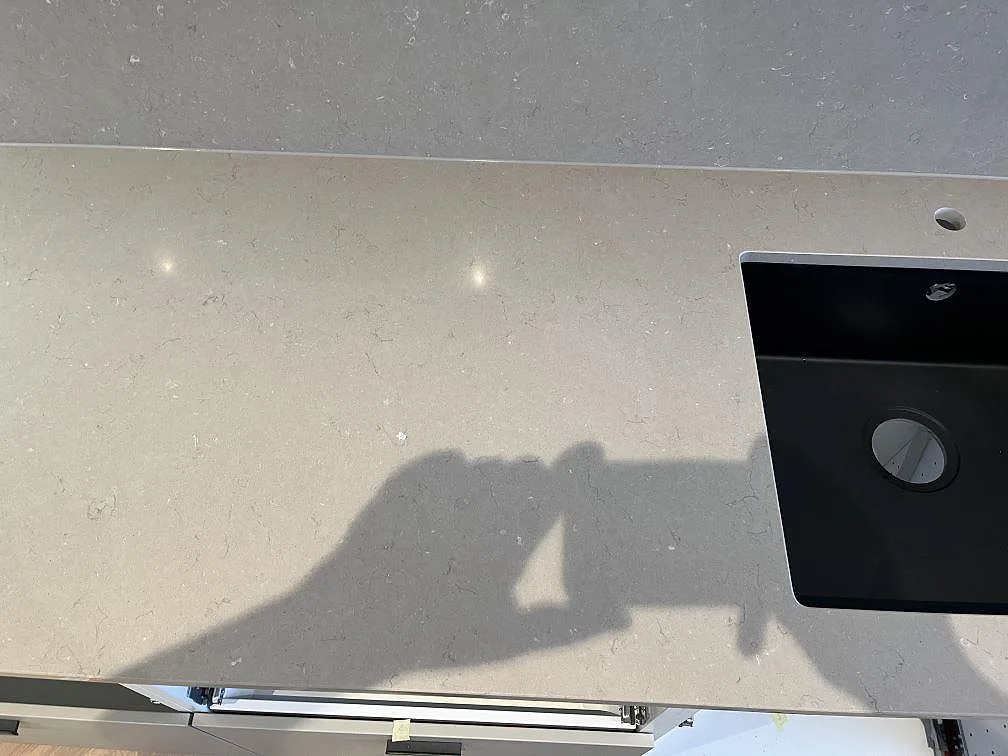 Polerad Silestone Coral Clay köksbänkskiva med underlimmad svart kompositdiskho i ett kök i Limhamn.