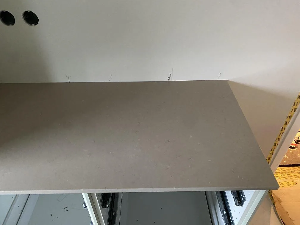 Ovanifrån på en monterad bänkskiva i greige Silestone Coral Clay med jämn ådring i ett kök i Limhamn.